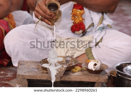 Performing Pooja for Hindu god siva linga with milk, honey and coconut water Royalty-Free Stock Photo #2298960261