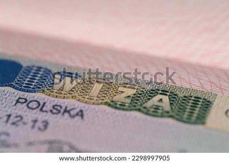 close-up part of page of document, foreign passport for travel with Poland visa, tourist schengen visa stamp with hologram with shallow depth of field, passport control at border, travel in Europe