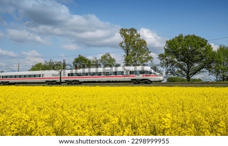The train passes through a sea of rape flowers Royalty-Free Stock Photo #2298999955