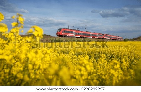 The train passes through a sea of rape flowers Royalty-Free Stock Photo #2298999957