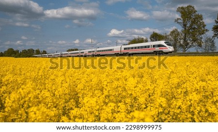 The train passes through a sea of rape flowers Royalty-Free Stock Photo #2298999975