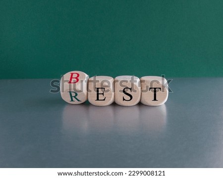 Best rest symbol. Turned wooden cubes and changed the word Rest to Best. Beautiful gray table blue background. Business and best rest concept. Copy space. Royalty-Free Stock Photo #2299008121