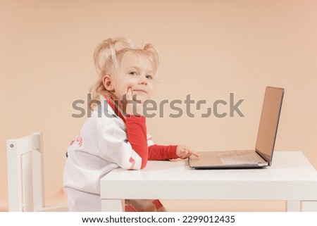 Girl doctor near the laptop looks at the camera and listens carefully