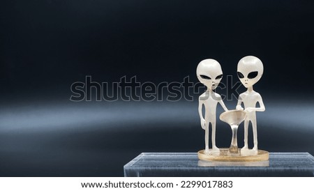 Grey alien plastic figure on dark background.