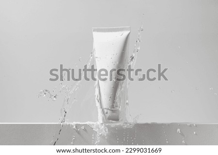 White mockup tube of cream with splash of water on isolated background. The concept of cosmetology, face and body care. Image for your design. Royalty-Free Stock Photo #2299031669