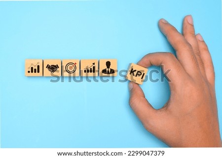 Key performance indicator, Businessman holding wooden cube with KPI Royalty-Free Stock Photo #2299047379