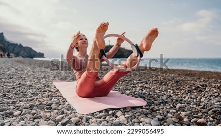 Woman sea pilates. Sporty happy middle aged woman practicing fitness on beach near sea, smiling active female training with ring on yoga mat outside, enjoying healthy lifestyle, harmony and meditation