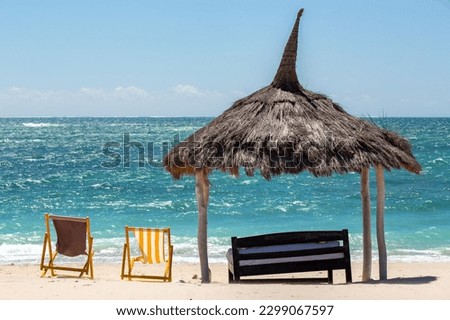 Tranquil and beautiful day on Anakao beach in Madagascar, with a clear blue sky, a comfortable sun lounger, and a colorful parasol for your ultimate relaxation. Toliara, Madagascar