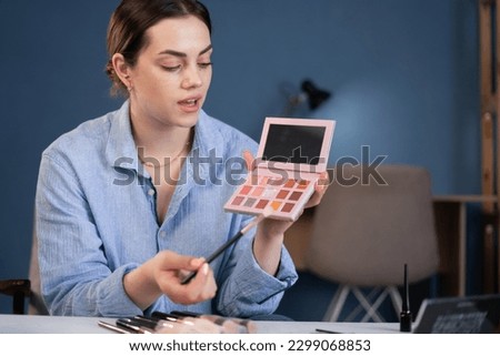 beautiful young female influencer talented blogger doing makeup, doing makeup reviews for vlog, giving advice to girls and women, filming the process on camera. webcam view Royalty-Free Stock Photo #2299068853