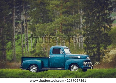 Classic oldtimer vintage American pick-up truck of the 1950s on a country road on a sunny summer day. Royalty-Free Stock Photo #2299069861