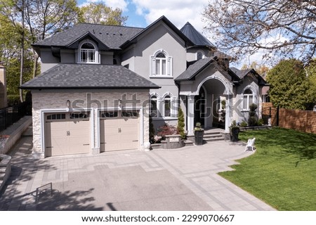 The drone footage captures the exquisite exterior of a million-dollar luxury home, showcasing its grandeur and beauty. From the sweeping driveway to the manicured landscaping and stunning design. Royalty-Free Stock Photo #2299070667