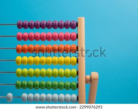 Wooden abacus on a blue background, Wooden abacus for children. Wooden abacus close-up. Royalty-Free Stock Photo #2299076293