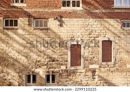 Detail of medieval house façade featuring ancient windows and brick wall in Maastricht, Nertherlands. Travel or medieval background. 
