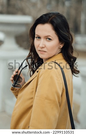woman walking in the park. woman in a yellow jacket. portrait of a woman. High quality photo