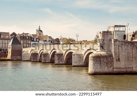View of Maastricht skyline with churches and bridge across Maas river in warm sunny day in May, Maastricht, the Netherlands. Travel or leisure vintage brown background.