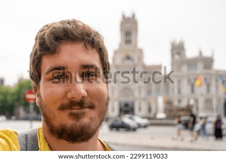 Young tourist man taking selfie in front of Palacio de Comunicaciones located on the Cibeles square in the Centre of Madrid, Spain Royalty-Free Stock Photo #2299119033