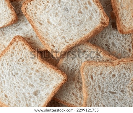 slice of white bread in full frame, popular food item in many cultures and used for making sandwiches, toast, and other dishes, lighter color and softer texture food background Royalty-Free Stock Photo #2299121735