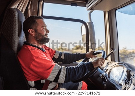 Truck driver driving on the highway, seen from inside the cab. Royalty-Free Stock Photo #2299141671