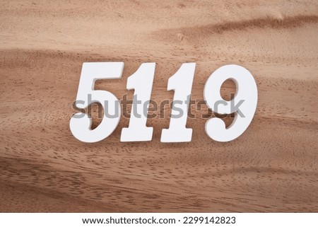 White number 5119 on a brown and light brown wooden background.