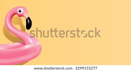 Trendy Summer composition made of pink flamingo inflatable on bright light yellow background.Minimal summer concept.Creative art,Contemporary style.Banner background with writing space and copy space.