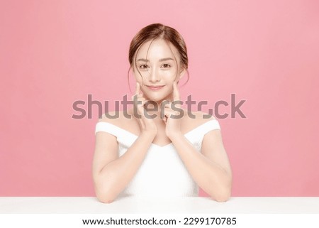 Young Asian beauty woman pulled back hair with korean makeup style touch her face and perfect skin on isolated pink background. Facial treatment, Cosmetology, plastic surgery. Royalty-Free Stock Photo #2299170785