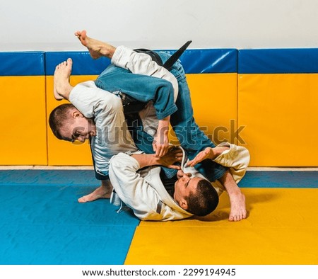Brazilian jiu-jitsu and grappling training for men in a self-defense gym Royalty-Free Stock Photo #2299194945