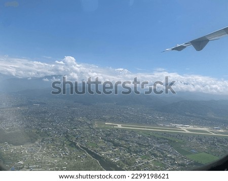 picture taken from the plane with beautiful pokhara international aiirport in the land and cloud in the high hill