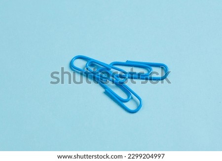 blue paper clips on blue background. Creative layout