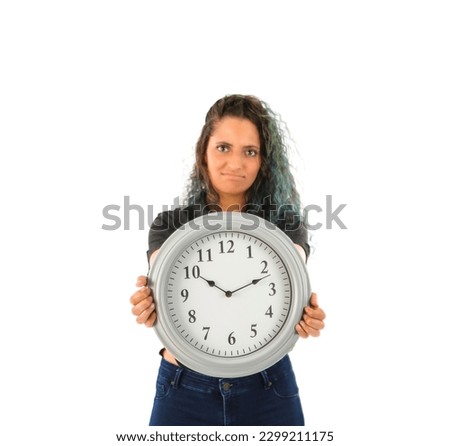 Serious young arab woman holding a clock against a white background