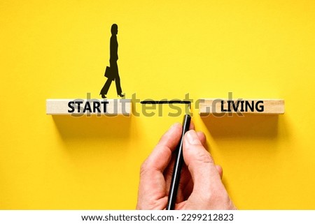 Start living symbol. Concept words Start living on beautiful wooden block. Beautiful yellow table yellow background. Businessman hand. Businesswoman icon. Business and Start living concept. Copy space