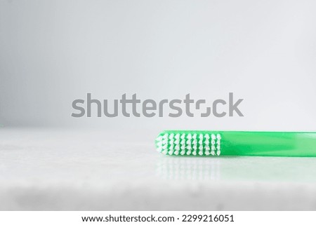 Green toothbrush with white bristles on a white background, Green toothbrush with copy space
