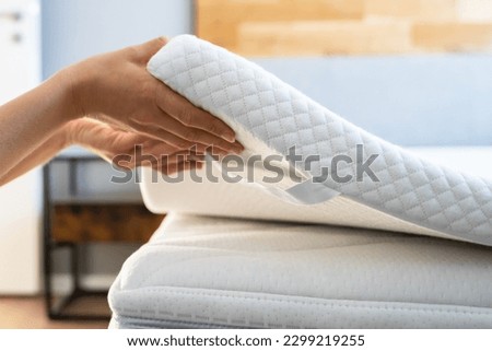 Mattress Topper Being Laid On Top Of The Bed Royalty-Free Stock Photo #2299219255