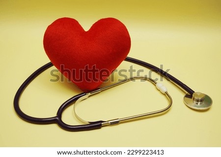 Red heart and Stethoscope on yellow background