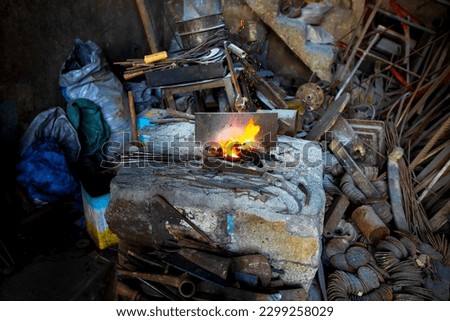 The current view of a burning fire and a blacksmith's workshop in the historical blacksmiths' bazaar in the center of Siirt.