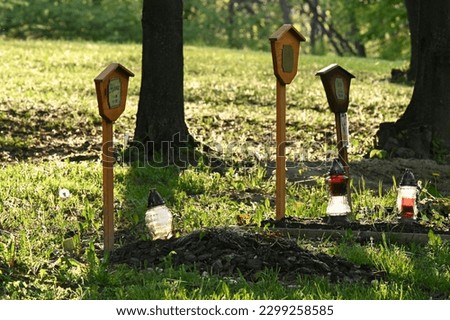 Three graves with lanterns in a pet cemetery Royalty-Free Stock Photo #2299258585