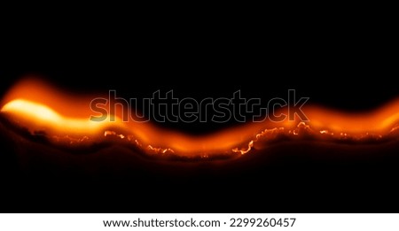 burning paper, glowing edge of paper on a black background Royalty-Free Stock Photo #2299260457