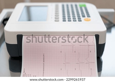 a cardiologist makes an ECG cardiogram for a patient prints an analysis of patient's pulse rate and heartbeat in the clinic