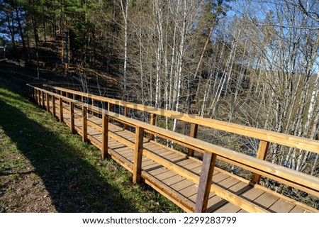 Wooden stairs with elevated walkway under construction, new construction, wooden structure, nature trail in forest Royalty-Free Stock Photo #2299283799