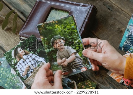 Person looks at printed photos for family photo album. Overhead shot.