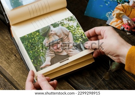 Female hands holds printed photo for family photo album.