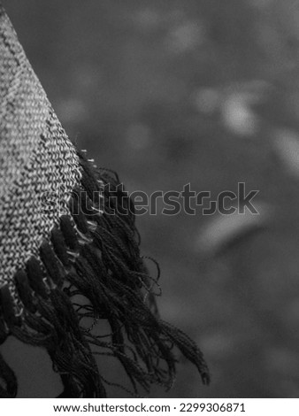 The tassel from the end of a prayer mat photographed close-up with a blurred background