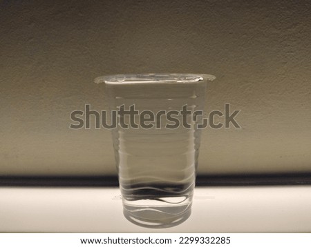plastic cup filled with water above the lamplight
