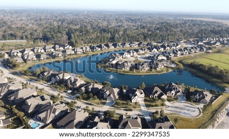  Serene lakeside living in Houston, featuring picturesque houses nestled beside a tranquil, small lake Royalty-Free Stock Photo #2299347535