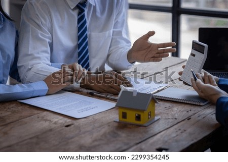 Closeup of Happy asian couple customers sign mortgage loan contract. Making lease and buy and sell house And contract home insurance mortgage loan concept