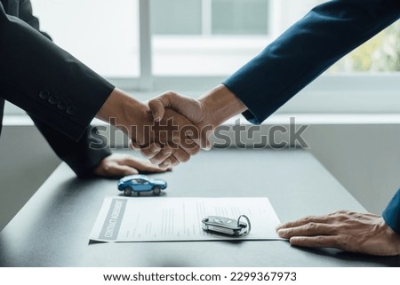 Shaking hands, Car insurance agent consulting with policy and contract to approved stamp rubber after signing.