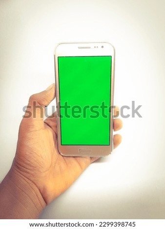 a green screen on a mobile phone held in hand 