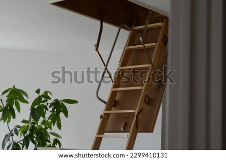 Ladder leading up to the attic inside the house. Royalty-Free Stock Photo #2299410131