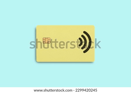 Bank credit card on a blue background. Yellow bank card. Credit card with contactless payment. Royalty-Free Stock Photo #2299420245