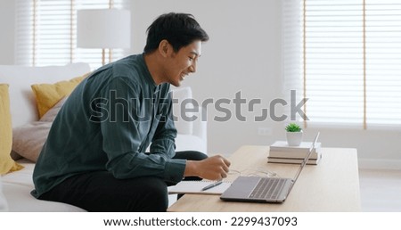 Gen Z asia people male guy work at home office sofa video call advice on laptop remote telework job online. Young adult hybrid worker man in reskill upskill career class look at webcam digital camera. Royalty-Free Stock Photo #2299437093