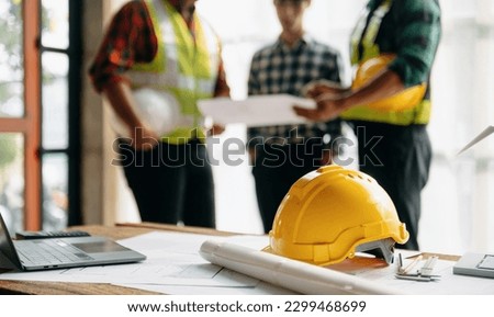 Engineer teams meeting working together wear worker helmets hardhat on construction site in modern city.Asian industry professional team in sun light
